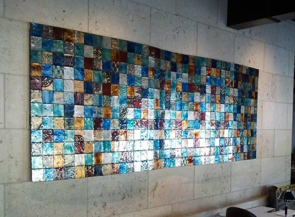 colorful tiled art piece installed on a tiled concrete wall