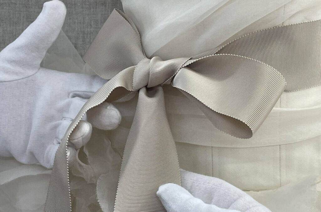 A detail of a bow from a Vera Wang wedding gown displayed in a custom vitrine